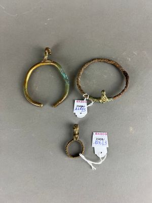 trois bagues en or et un bracelet sont posés sur une table
