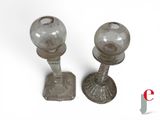 two glass candlesticks sitting on a white surface