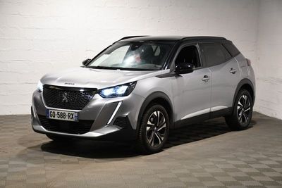 Le SUV argenté est garé dans une pièce blanche au sol carrelé.