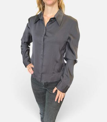 une femme vêtue d'un t-shirt noir et d'un jean, posant pour une photo