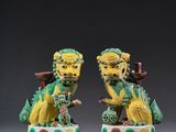 deux figurines vertes et jaunes représentant un dragon et un lion