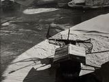photographie en noir et blanc d'un bateau amarré sur la rive d'une rivière