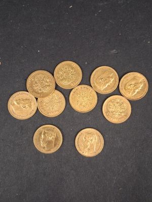 quelques pièces d'or posées sur une surface noire, en petit nombre