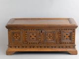 un vieux coffre en bois orné de panneaux sculptés et doté de tiroirs sur le dessus