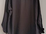 a black shirt hanging up on a hanger on a wall