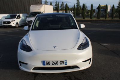une voiture blanche garée dans un parking à côté d'autres voitures