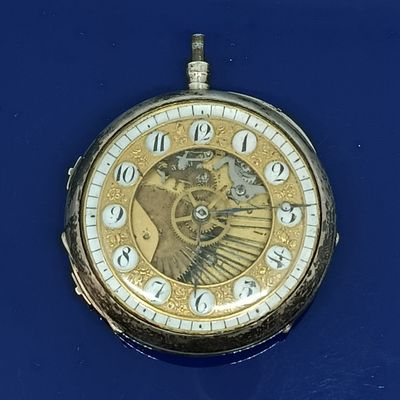 une montre de poche en or avec des chiffres romains sur le cadran
