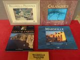 trois livres posés sur une table rouge sur laquelle est posée une plaque