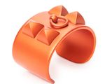 an orange cuff bracelet with a bow on it on a white surface