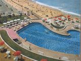 a poster of a beach with a swimming pool in the middle of it