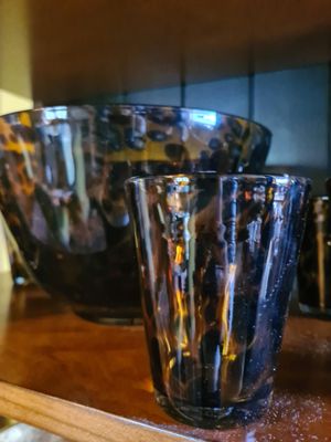 de nombreux verres posés sur une étagère en bois dans une cuisine
