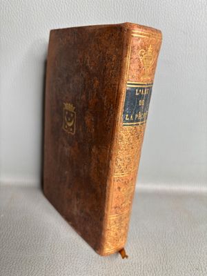 an old book sitting on top of a table next to a white wall