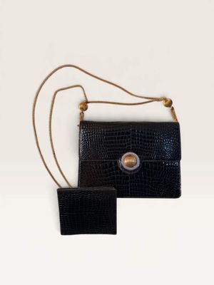 two pieces of black alligator skin purses on a white surface