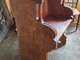a wooden bench in a room with a picture on the wall