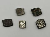 five different types of silver and bronze coins on a white surface