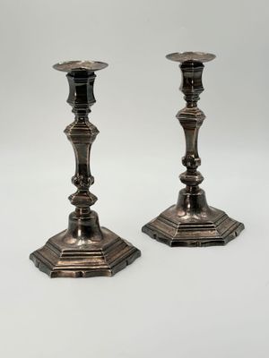 pair of antique silver candlesticks on a white background