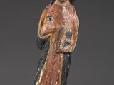 une vieille figurine représentant une femme tenant un livre