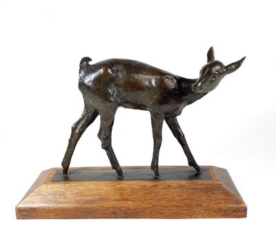 bronze statue of a deer on a wooden base on a white background