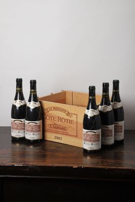 six bouteilles de vin posées sur une table à côté d'une caisse de vin