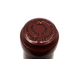 a close up of a bottle of wine on a white surface