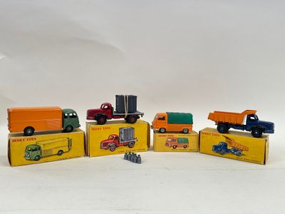 several toy trucks are lined up in a row on a white surface