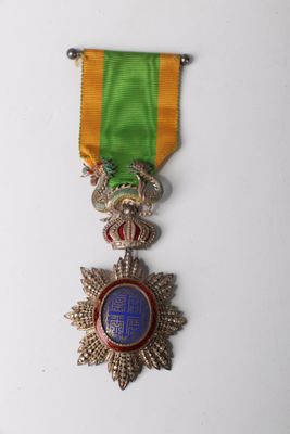 a close up of a medal on a white surface with a green ribbon