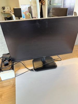 un écran d'ordinateur posé sur un bureau en bois