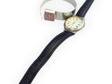 a watch and a ring on a white surface