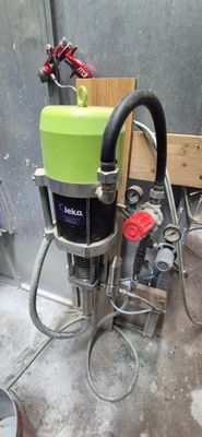 une photo d'une machine verte et noire dans un garage