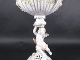 un vase blanc orné de fleurs, posé sur un socle
