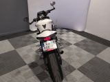 a white motorcycle parked in a room with a checkered floor