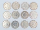 a group of twenty different coins on a white surface