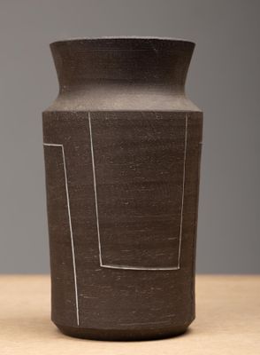 un vase noir posé sur une table en bois