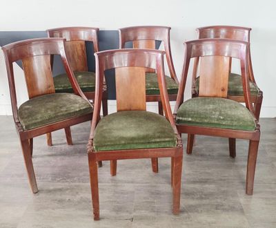 quatre chaises en bois avec des assises recouvertes de velours vert dans une pièce