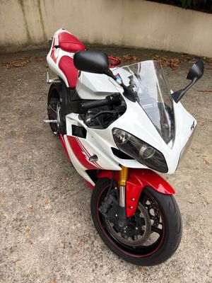 a red and white motorcycle parked in a parking lot