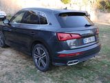 the rear end of a black audi suv parked in a grassy area