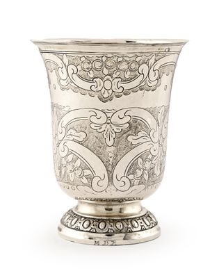 vase en argent orné d'un motif élaboré sur un socle, sur fond blanc
