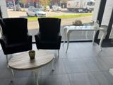 two chairs and a table in a room with a view of the street