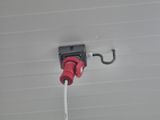 une prise électrique rouge et noire fixée à un mur blanc