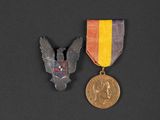 two medals and a medal on a black surface
