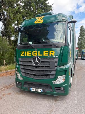 un camion vert garé sur le bord de la route