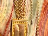 a necklace with a picture of a man on it on a mannequin