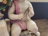 a figurine of a boy and a girl sitting on a rock