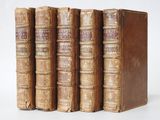 three old books sitting on top of each other on a white surface
