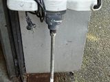 a white electric drill sitting on the side of a building