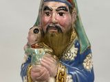 a figurine of a man with a beard holding a dog