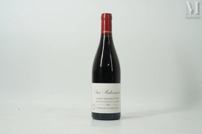 une bouteille de vin rouge posée sur une table blanche