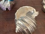 two silver figurines sitting on a table next to each other