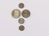 several different coins are arranged in a row on a white surface