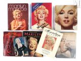 Plusieurs livres consacrés à Marilyn Monroe sont alignés sur une surface blanche
